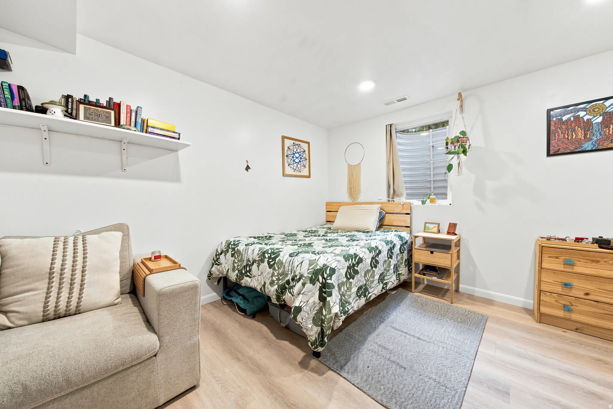 Bright bedroom featuring recessed lighting, a window with horizontal blinds, and wood-finish flooring
