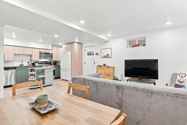 Open-concept living space featuring recessed lighting, light wood-finish flooring, and a kitchen with two-tone cabinetry
