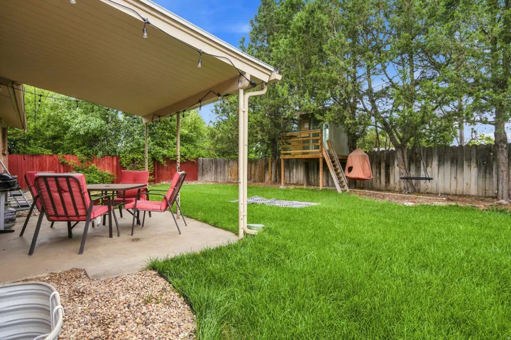 Expansive backyard featuring a covered patio, concrete surface, gravel accent, and a privacy fence