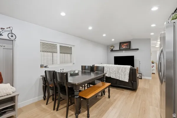 Open-concept living area with light wood-finish flooring, recessed lighting, and a neutral wall palette