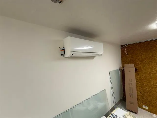 Wall-mounted air conditioning unit with visible conduit