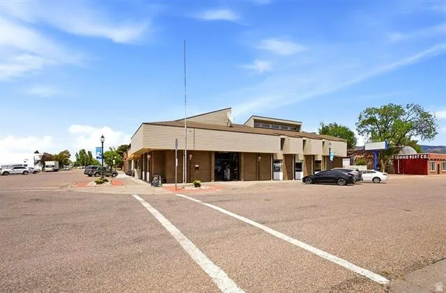 Commercial building with a multi-level roofline, horizontal siding, and multiple large storefront windows