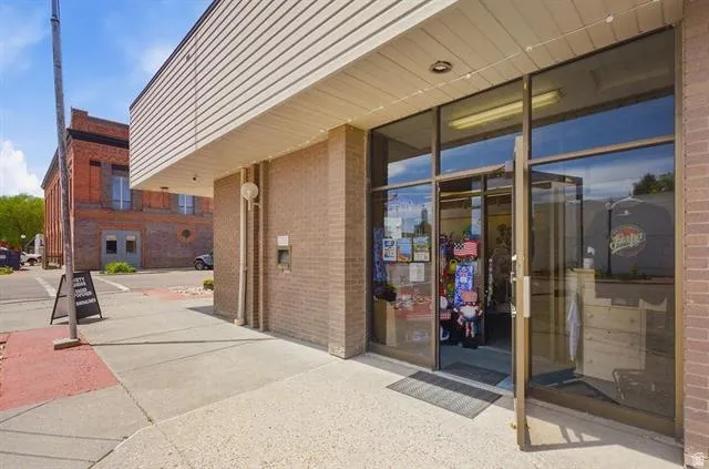 Brick exterior with full-light glass storefront and a cantilevered awning