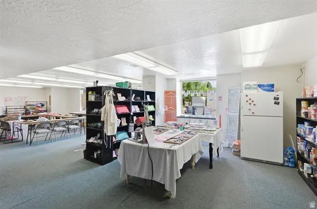 Carpeted interior space featuring recessed lighting, a white painted ceiling, and a large window