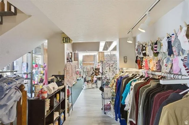 Retail space featuring track lighting, wood-finish flooring, and an open stairway