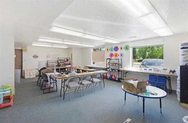 Spacious room featuring carpet flooring and multiple windows providing natural illumination