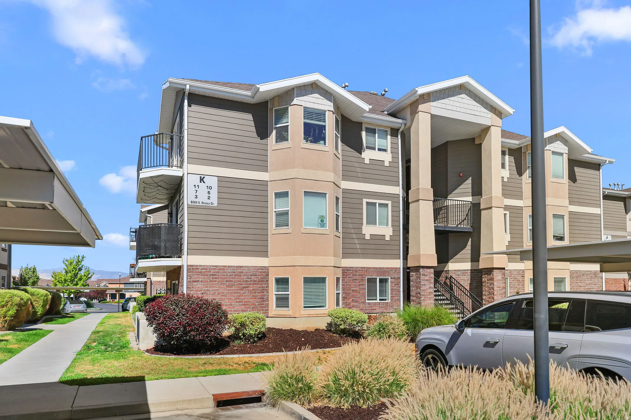 Multi-level building exterior featuring a mix of horizontal siding and brick veneer