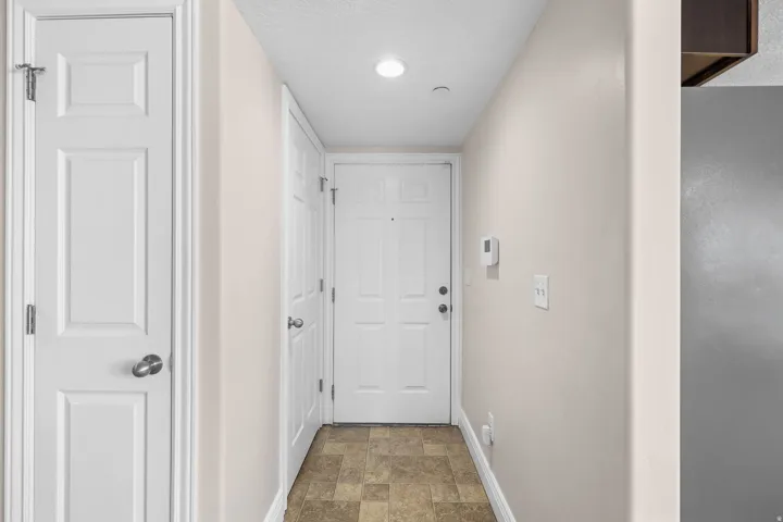 Entryway featuring a paneled door, recessed lighting, and neutral wall paint