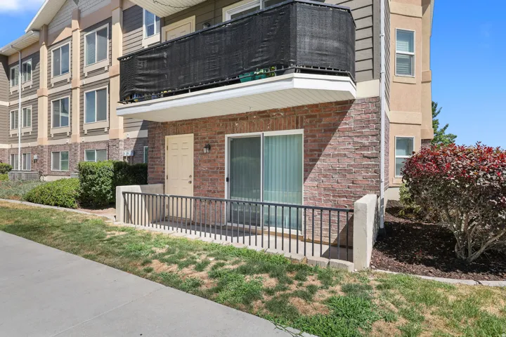 Ground-level patio entry featuring brick veneer siding and a sliding glass door