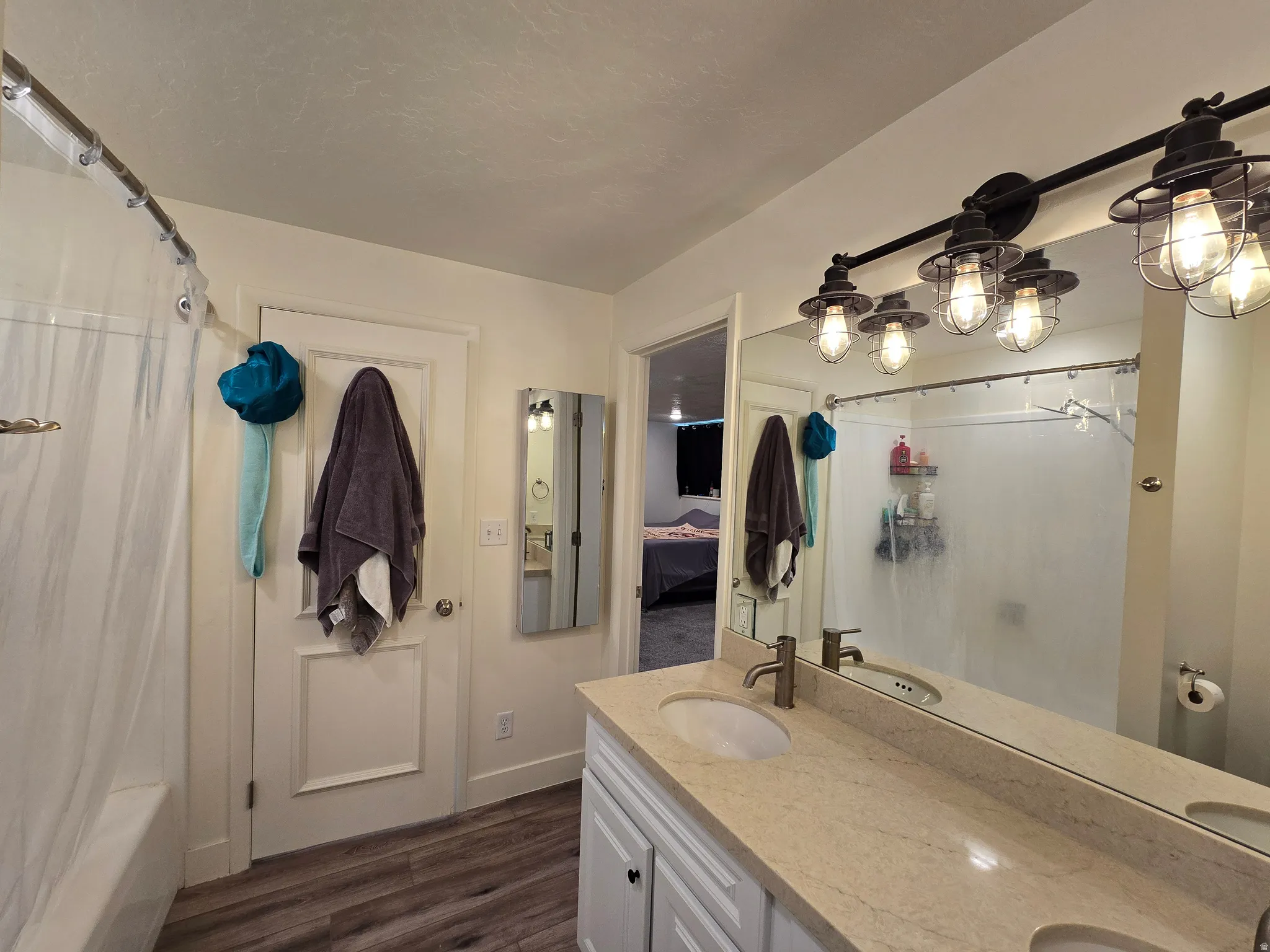 Bathroom vanity featuring a light-toned countertop, dual undermount sinks, and a full-width mirror