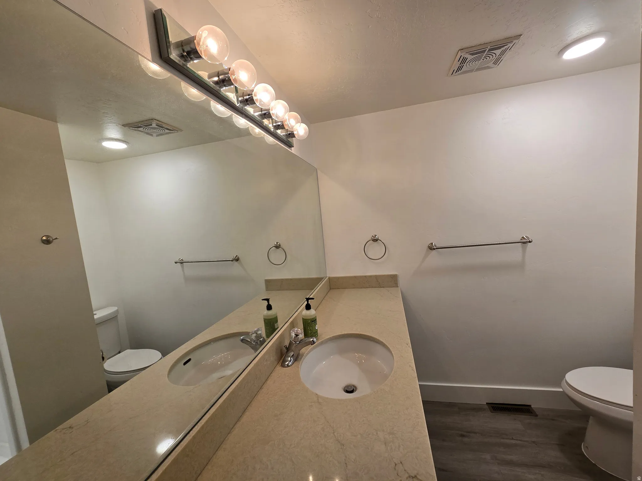 Dual vanity with integrated sinks, stone-finish countertop, and chrome fixtures