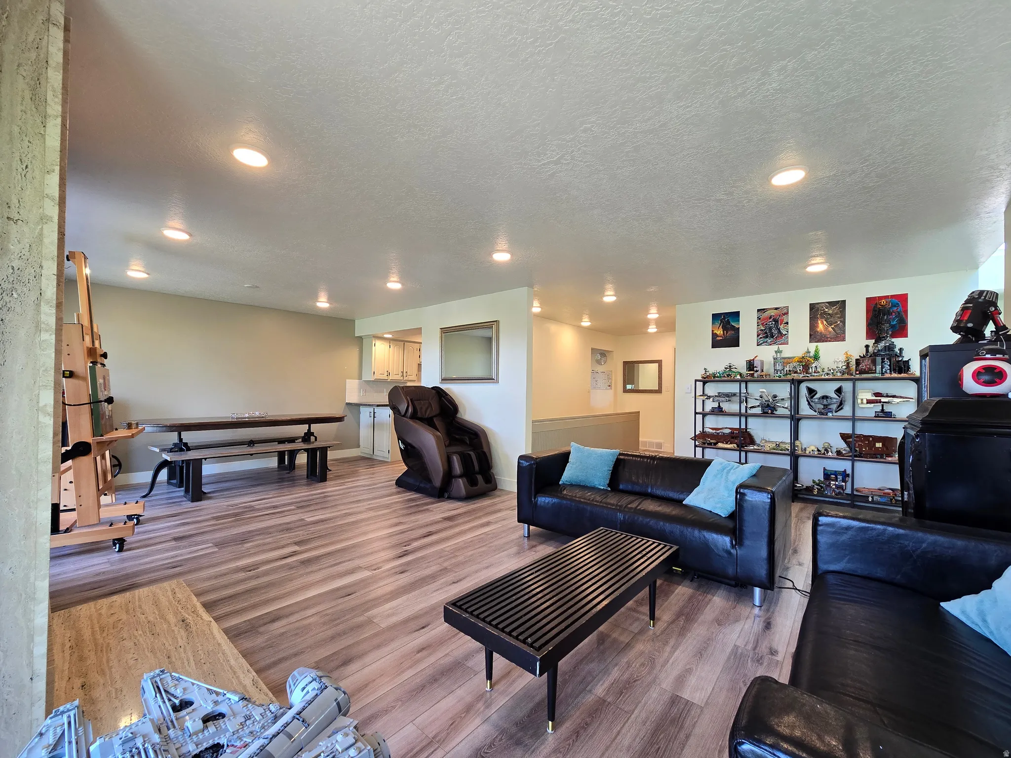Spacious entertainment area featuring wood-finish flooring and recessed lighting