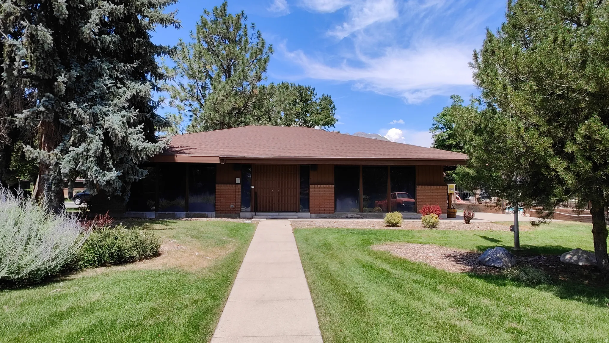 Single-story residence featuring a brown roof and brown siding