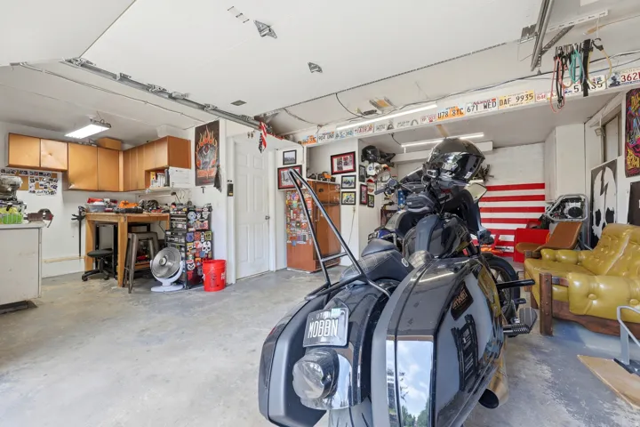 Finished garage space featuring concrete flooring, track lighting, and a built-in workbench with wood-finish cabinetry