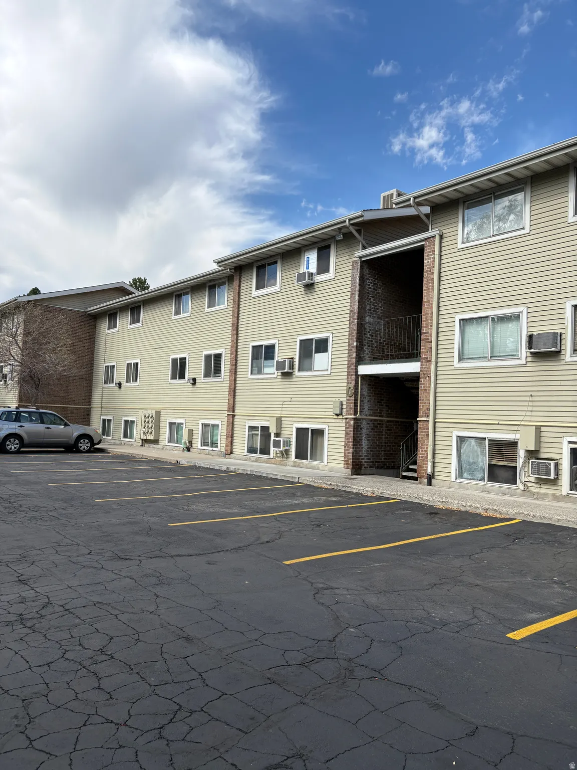 Multi-story building featuring horizontal siding and brick accents