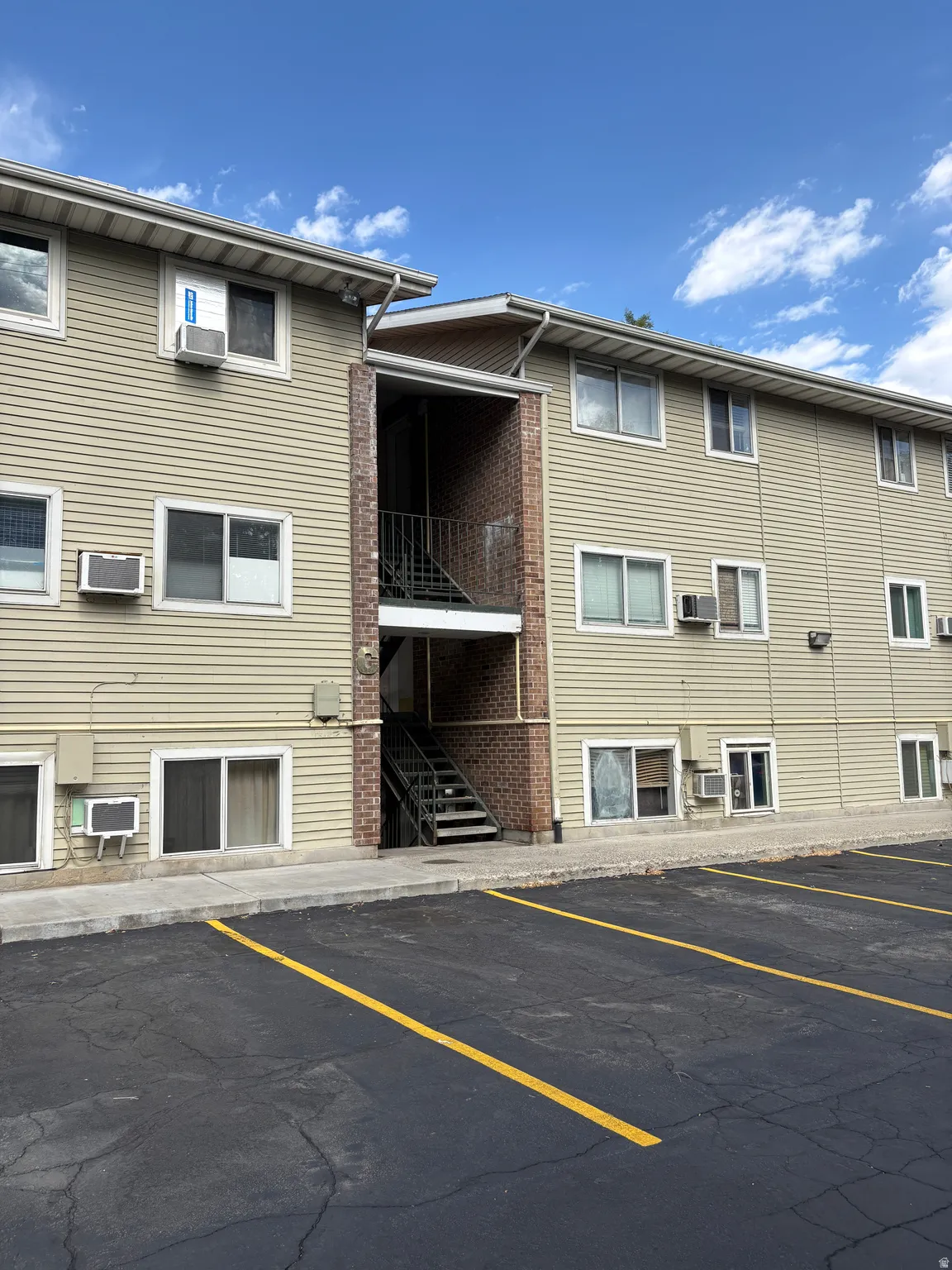 Multi-level building with horizontal siding and prominent window units