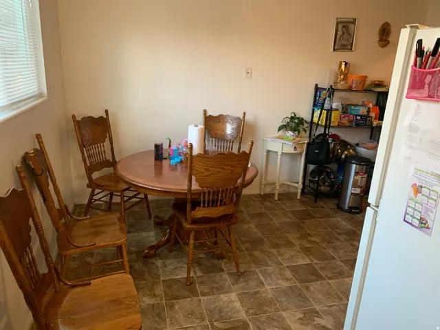 Kitchen area featuring tile flooring, white walls, and a window with blinds