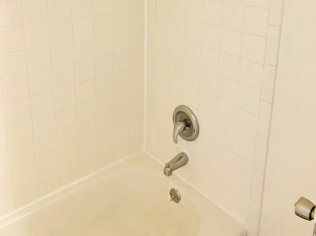 Bathtub with square tile surround and chrome fixtures