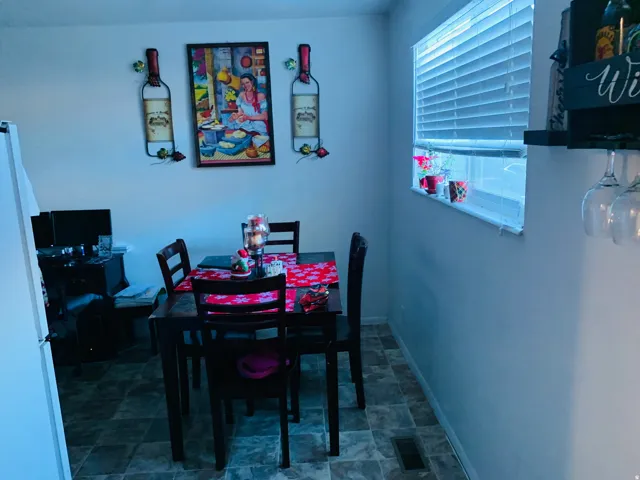 Dining area featuring a dark wood-finish dining table and matching chairs, complemented by patterned resilient flooring