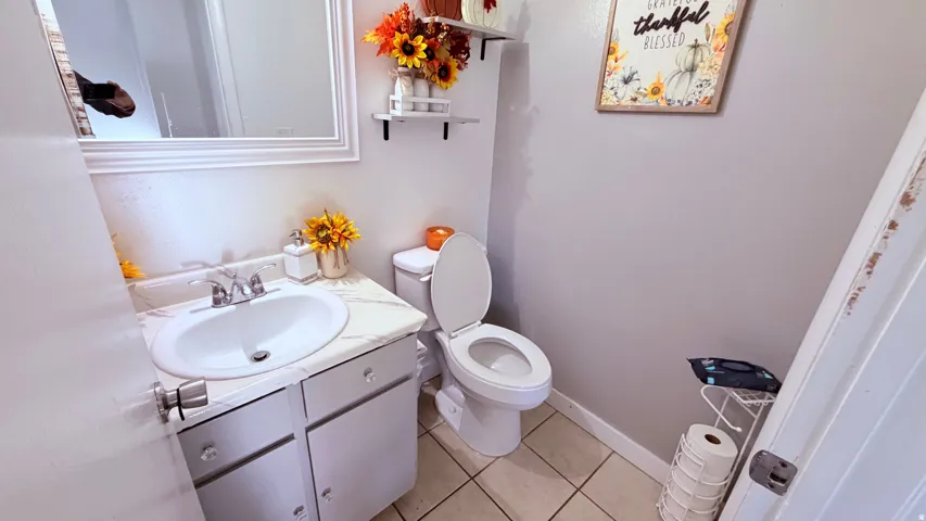 Bathroom vanity featuring a white oval sink, chrome faucet, and a stone-finish countertop