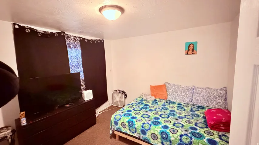 Bedroom featuring carpeted flooring, a flush-mount ceiling light, and white wall finishes