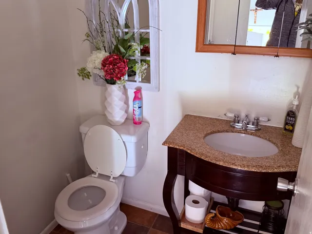 Bathroom featuring a vanity with a granite-look countertop and an integrated white sink