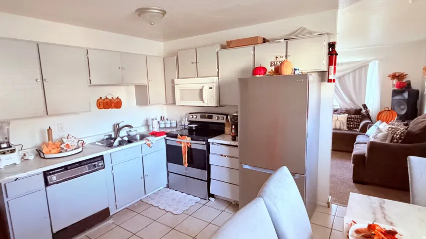 Kitchen featuring light-toned cabinetry, a white countertop, and tiled flooring