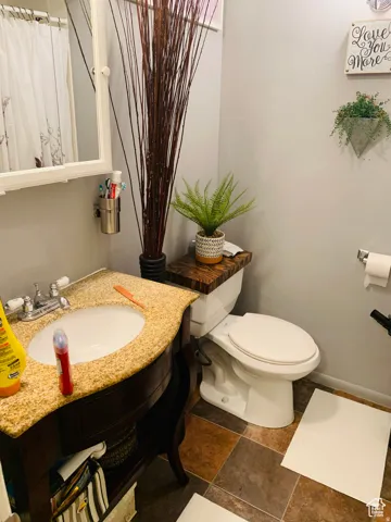Bathroom featuring a dark wood vanity with a granite-finish countertop and an integrated sink