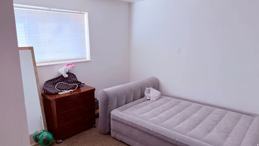 Carpeted room featuring a single window with horizontal blinds