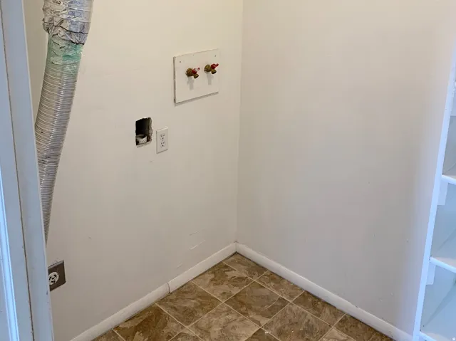 Utility room featuring a dryer vent, washing machine hookups, electrical outlets, and built-in shelving