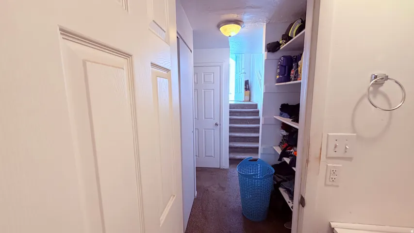 Hallway featuring white paneled doors, built-in shelving, and overhead lighting