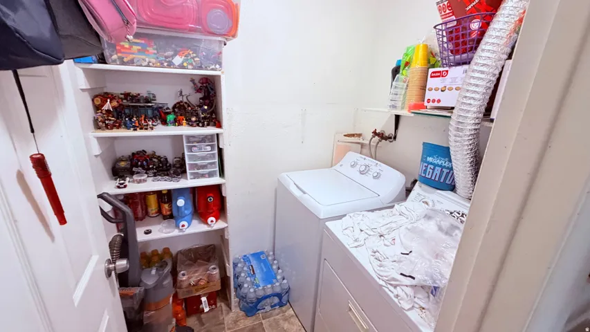 Laundry area featuring a side-by-side washer and dryer, built-in shelving, and a vinyl floor