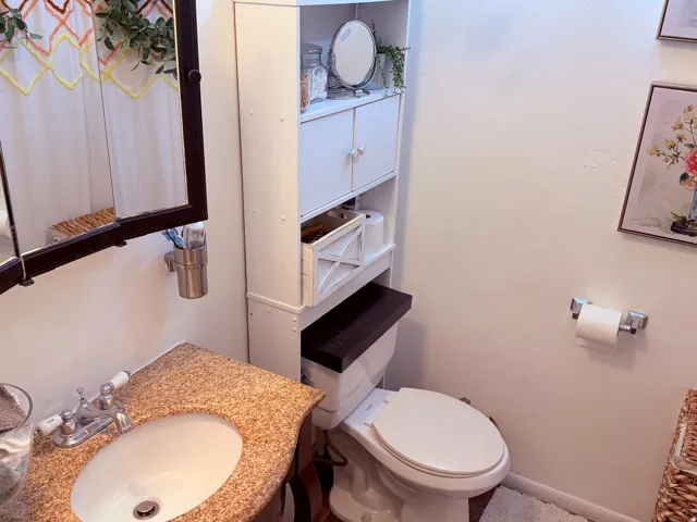 Bathroom featuring a vanity with a speckled countertop, an undermount sink, and a framed medicine cabinet