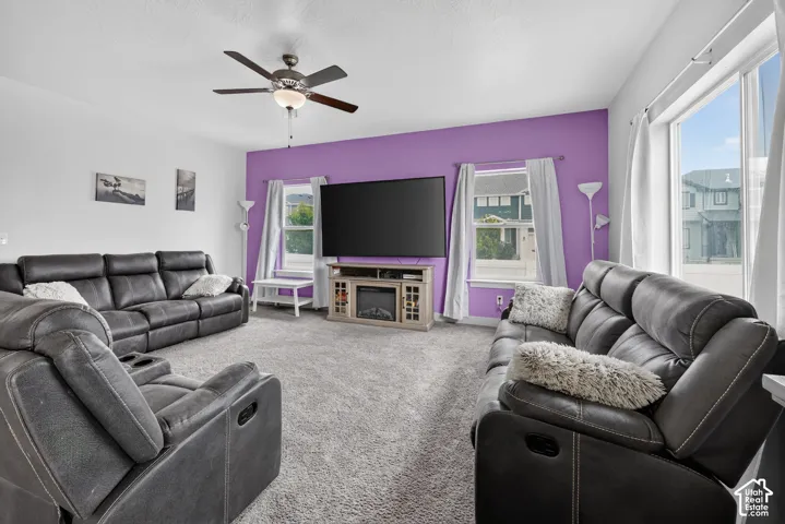 Spacious living area featuring neutral carpeting and a distinct accent wall