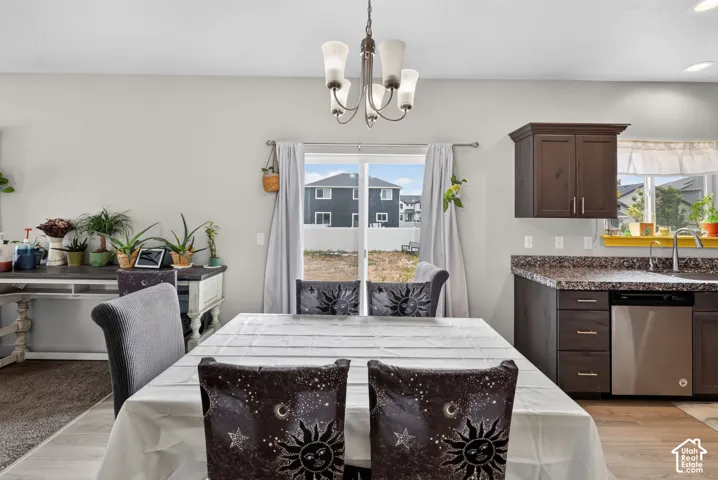 Bright dining area featuring light gray walls and a multi-light chandelier