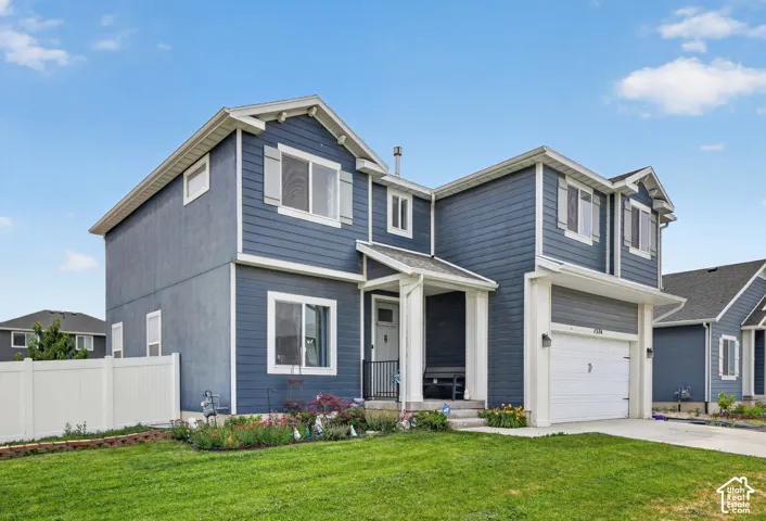 Two-story residence featuring blue siding, white trim, and a covered entry