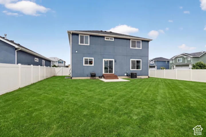 Expansive grass lawn bordered by a white vinyl fence