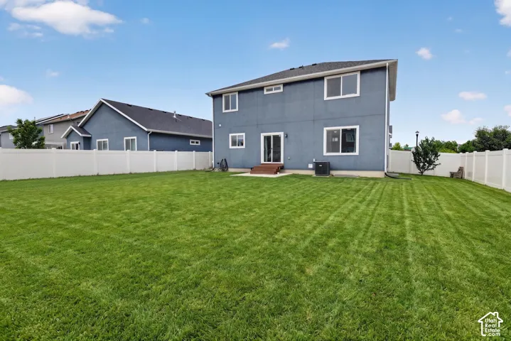 Expansive lawn with a white vinyl privacy fence encompassing the perimeter