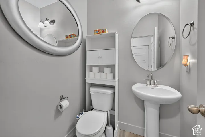 Pedestal sink with chrome faucet, complemented by an oval mirror