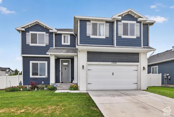 Two-story home with a two-car garage, dark blue siding, white trim, and a concrete driveway