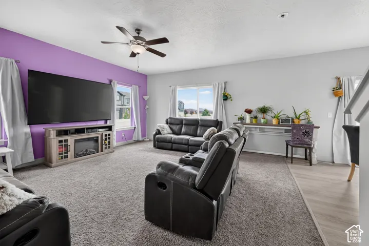 Spacious living area featuring neutral carpeting and a distinct accent wall
