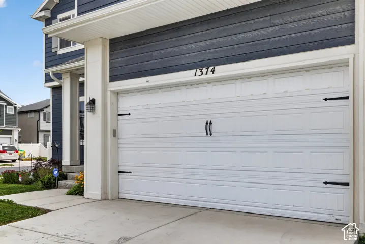Attached single-panel garage door featuring decorative black hardware