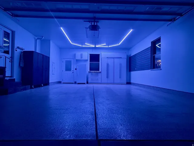 Spacious garage featuring a durable epoxy floor finish and integrated overhead lighting