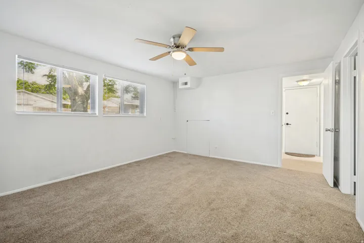 Spacious room with light tan carpeting and white walls