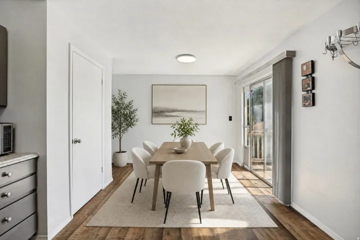 Dining area featuring wood-finish flooring, white walls, and a sliding glass door