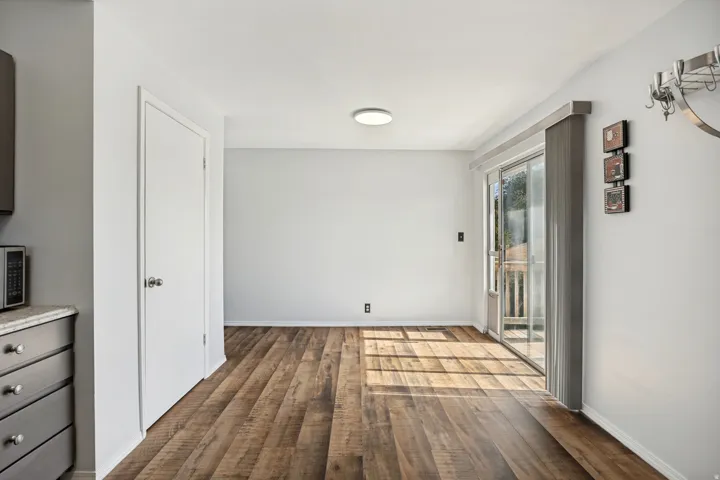 Open-concept room featuring wood-finish flooring, white walls, and a recessed ceiling light