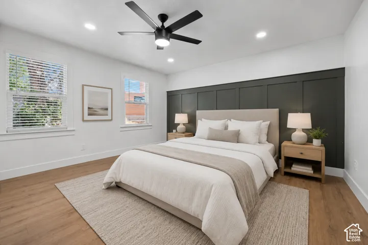Expansive room featuring wood-finish flooring, recessed lighting, and a black ceiling fan