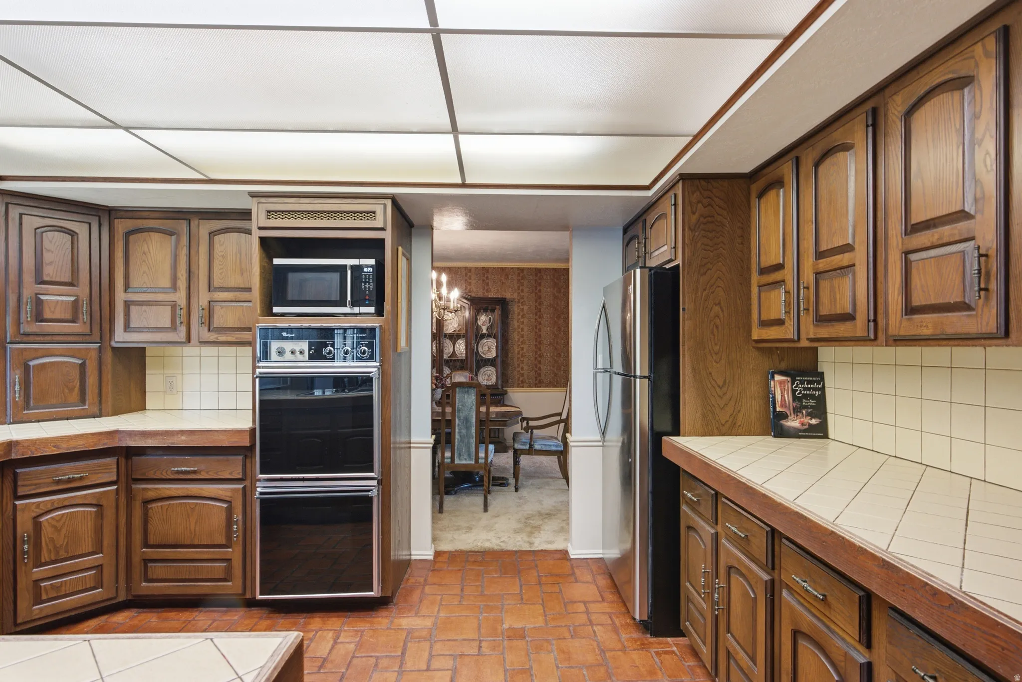 Kitchen featuring extensive wood-finish cabinetry, tile countertops, and a built-in double oven