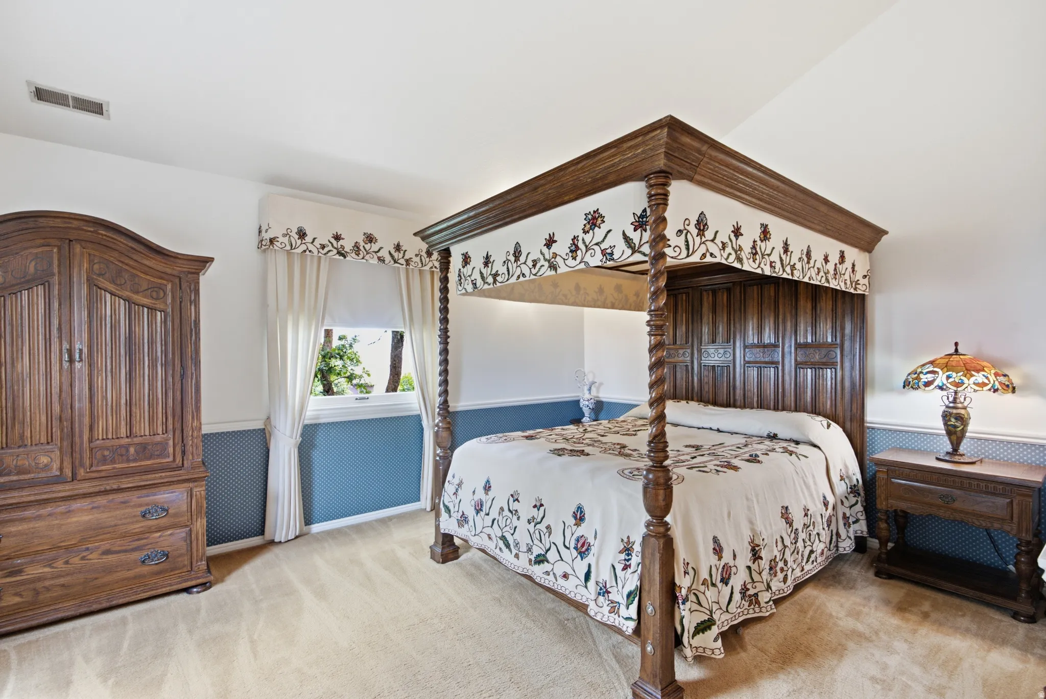 Carpeted room featuring a window with white blinds and curtains, a built-in air vent, and two-tone walls with patterned wainscoting