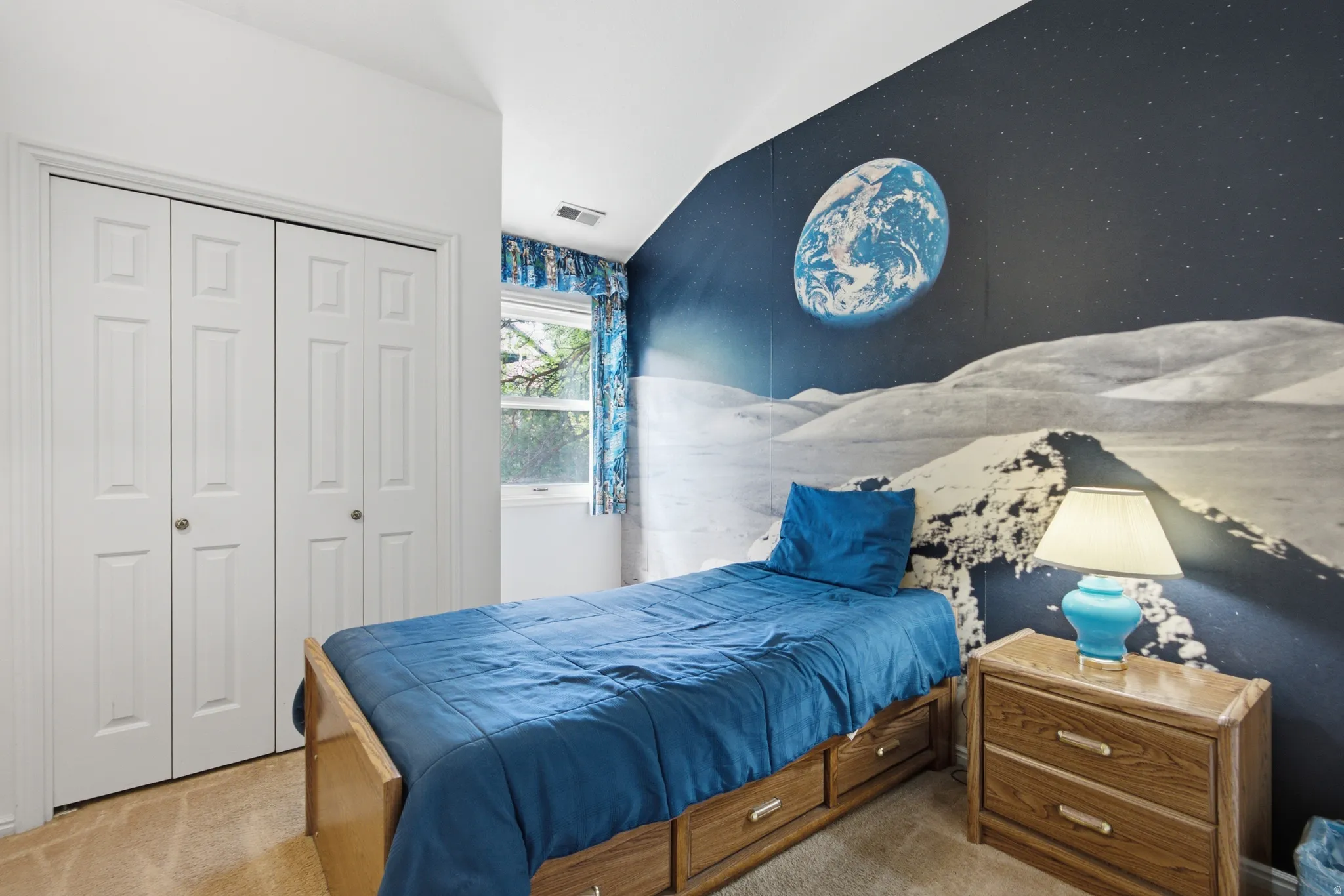 Space-themed accent wall with a moonscape mural